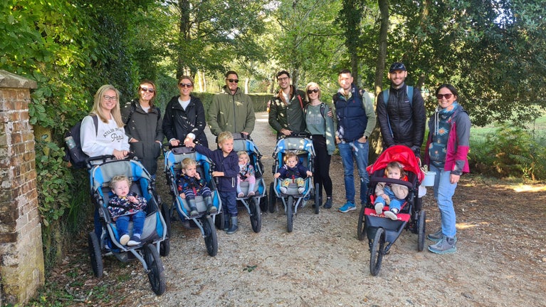 A group of families with hire pushchairs with children.